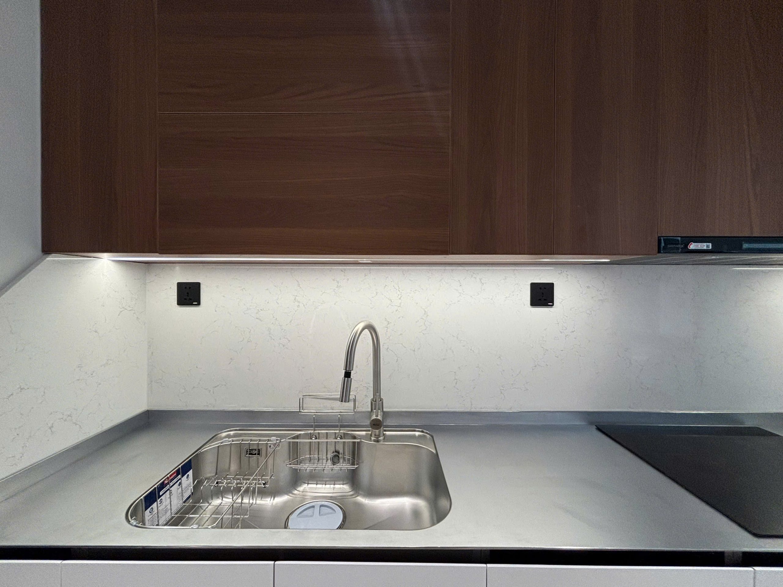 Không gian bếp hiện đại sử dụng mặt bàn inox kết hợp tủ trên vân gỗ